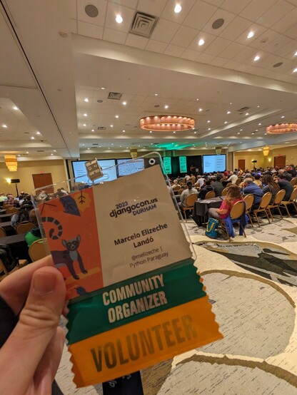 DjangoCon Lanyard with my name on it, in the back there's the conference room with a lot of people